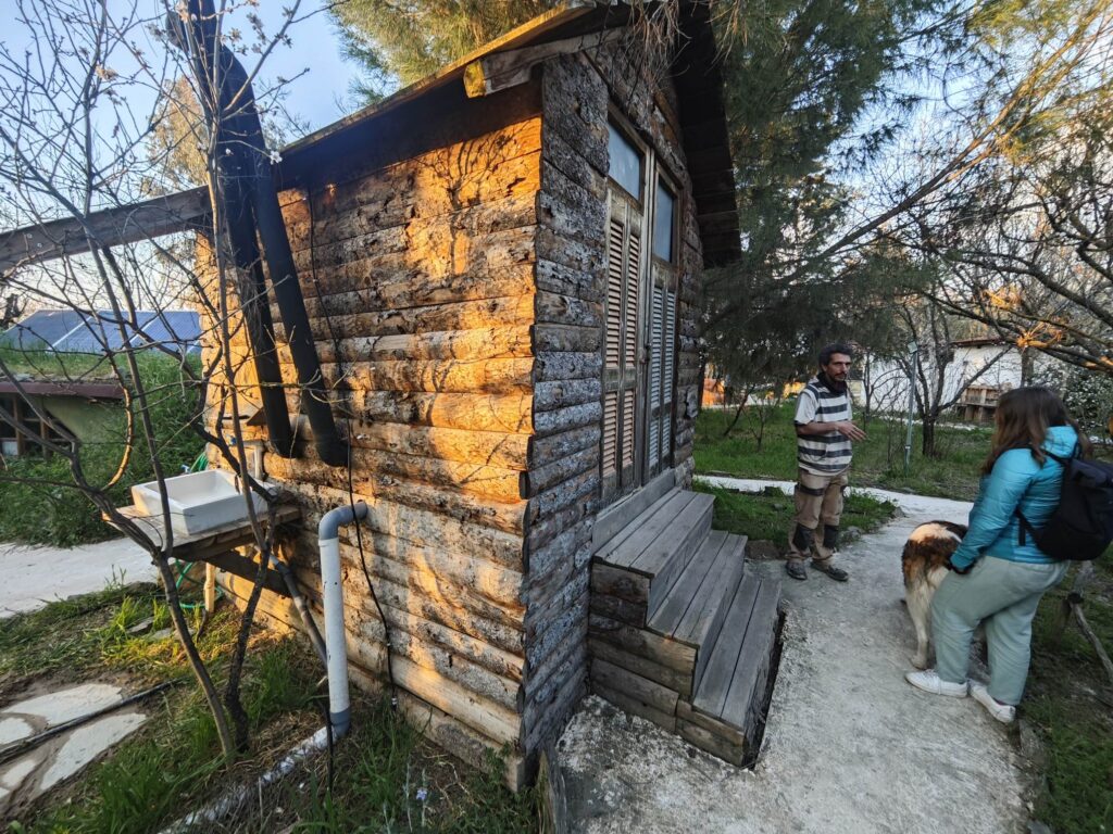 People and dogs at an eco farm near Larisa, Greece with natural buildings made of clay and straw