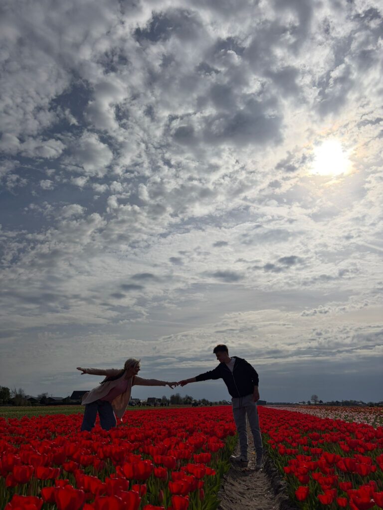 International exchange participants posing in colorful tulip fields at Keukenhof
