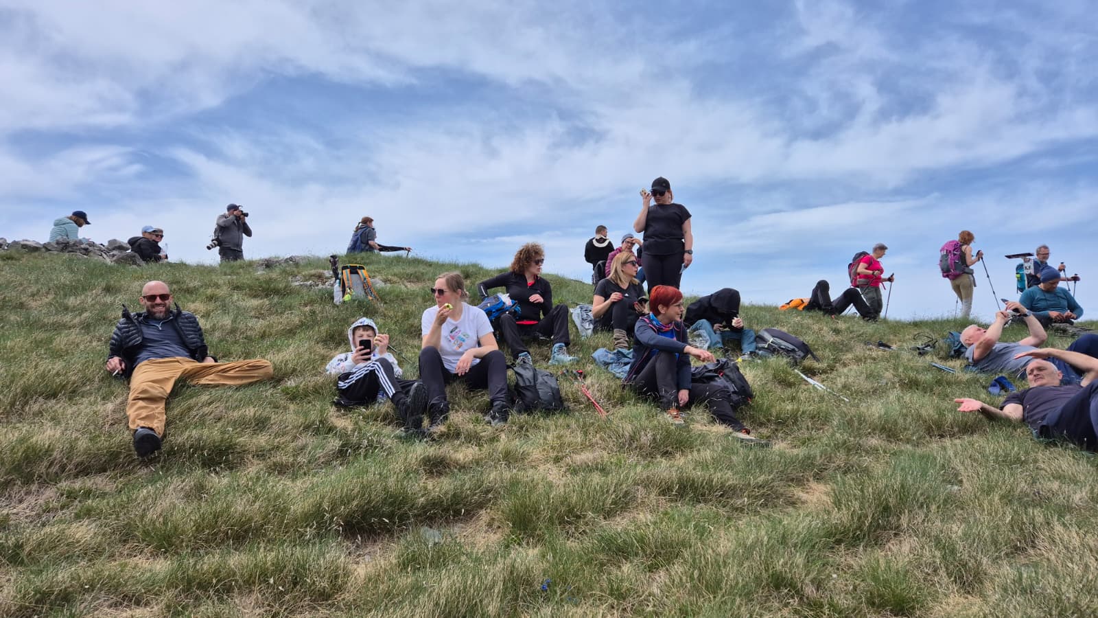 Participants of the 12 Peaks – Challenge Up project resting together on a grassy mountain ridge during a group hike on Velebit Mountain
