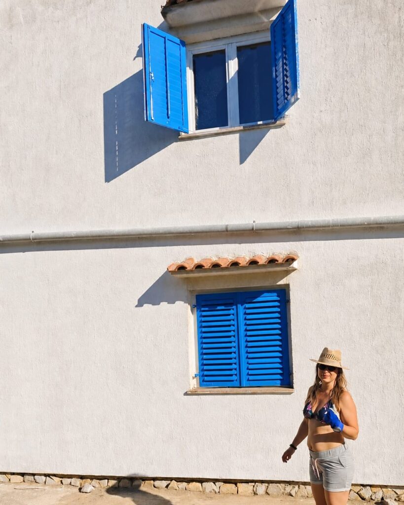 Traditional house on Krk with freshly painted blue shutters inspired by Greek architecture