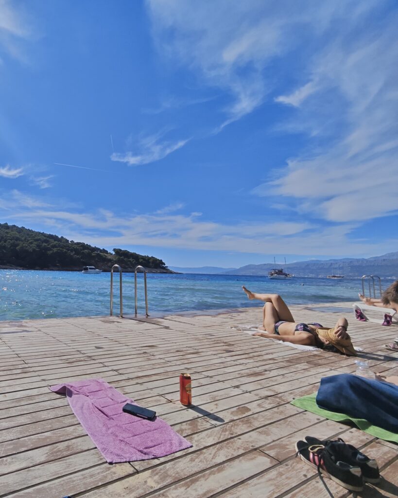 Relaxing by the crystal-clear sea at Lovrečina Beach on Brač Island, Croatia.