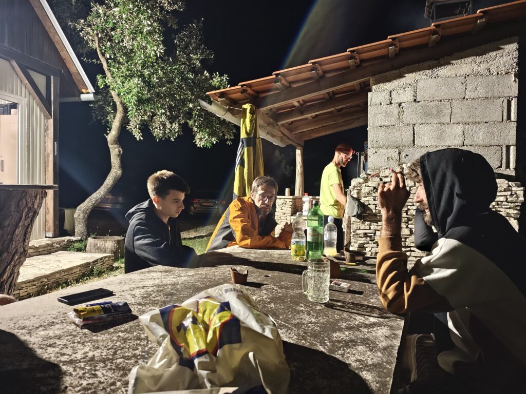 Participants of the 12 Peaks Challenge Up project sharing an evening gathering outside Gažul Mountain Hut on Brač Island.