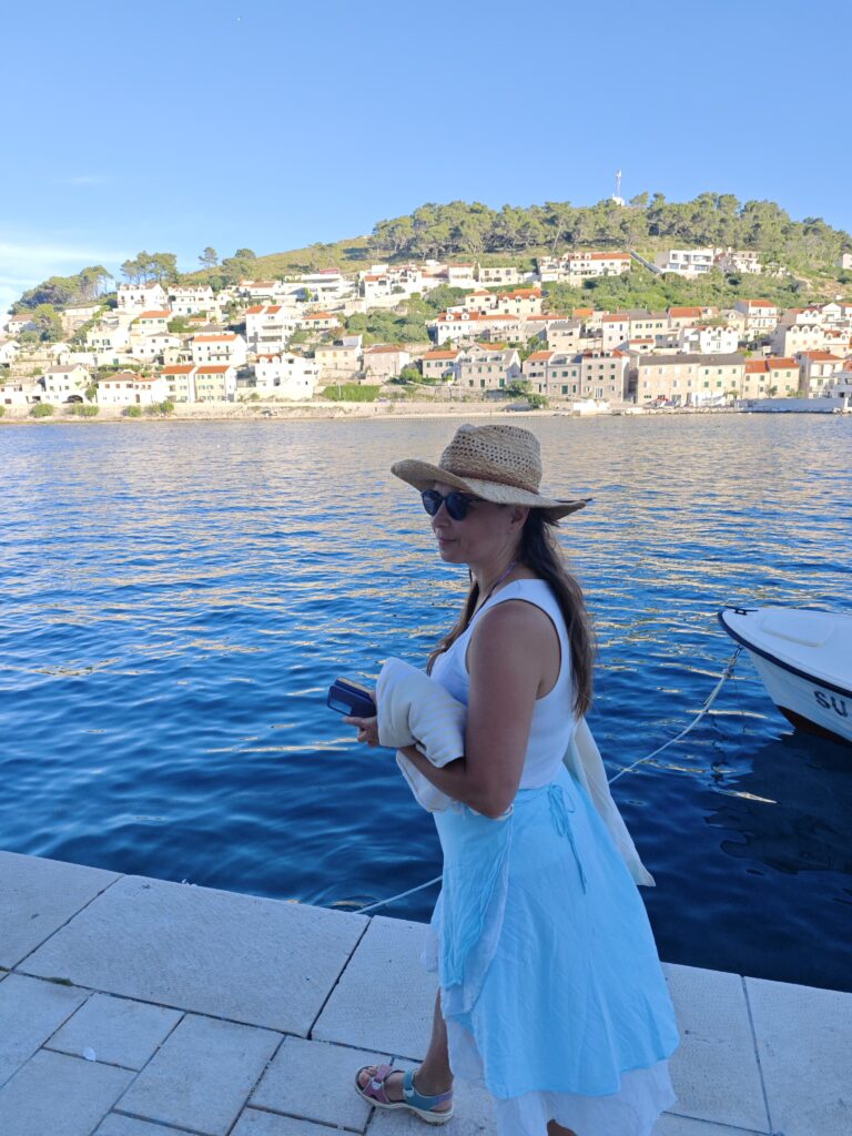 Participant of the 12 Peaks Challenge Up project standing by the waterfront in Pučišća, one of the most beautiful stone-built villages on Brač Island.