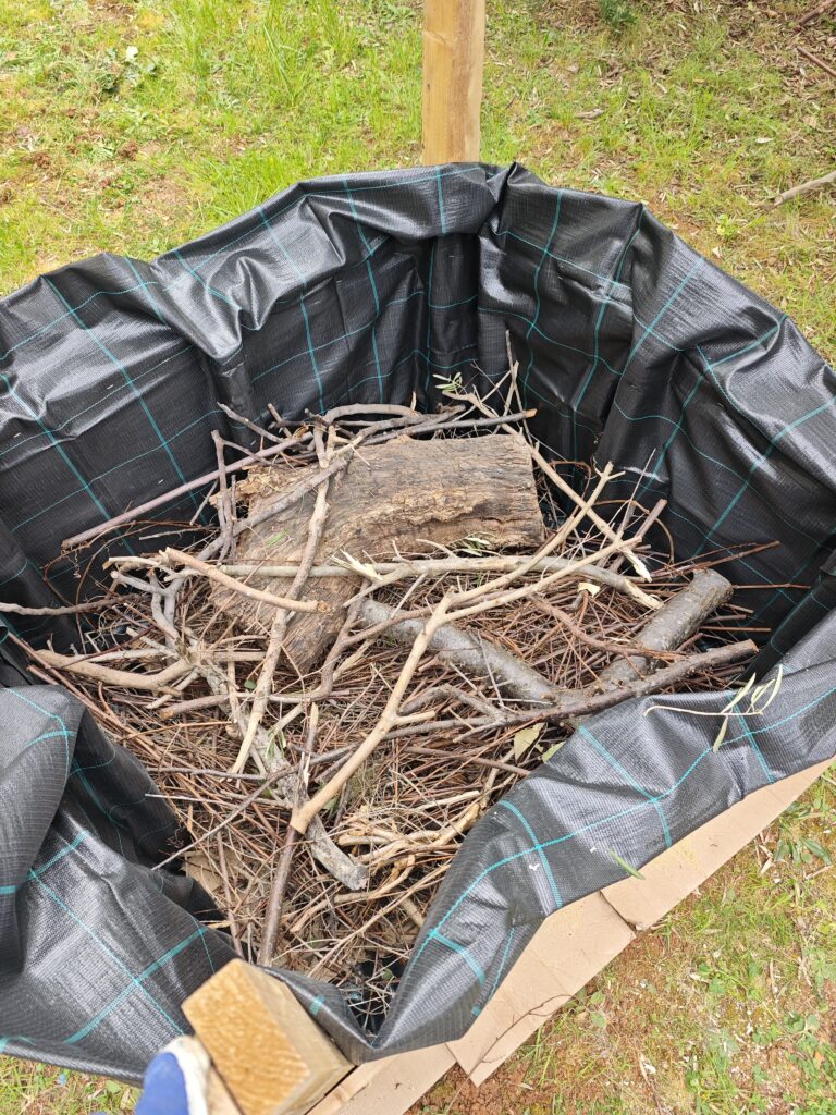 Building a hugelkultur raised garden bed in Croatia using branches and recycled wood